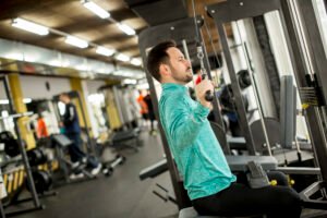 Man doing excersise on a lat machine in gym